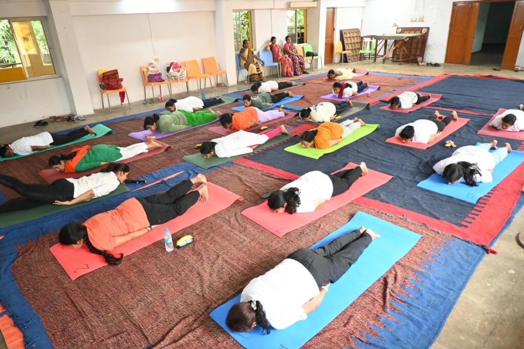 Group yoga participants practicing Bhujangasana (Cobra Pose) during a guided yoga session at Divine Path Yoga